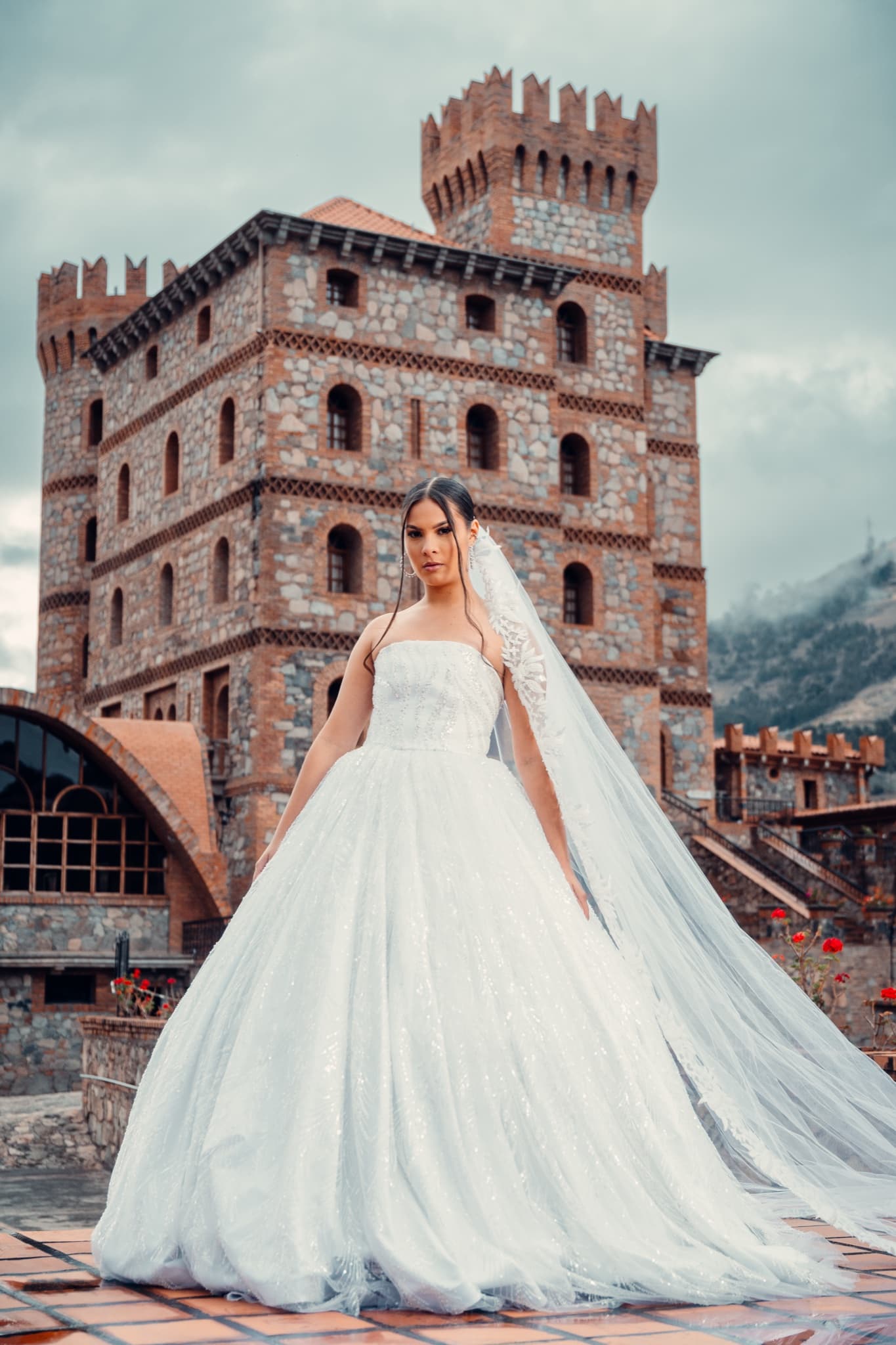 Retrato vertical de novia con vestido blanco y arquitectura de piedra