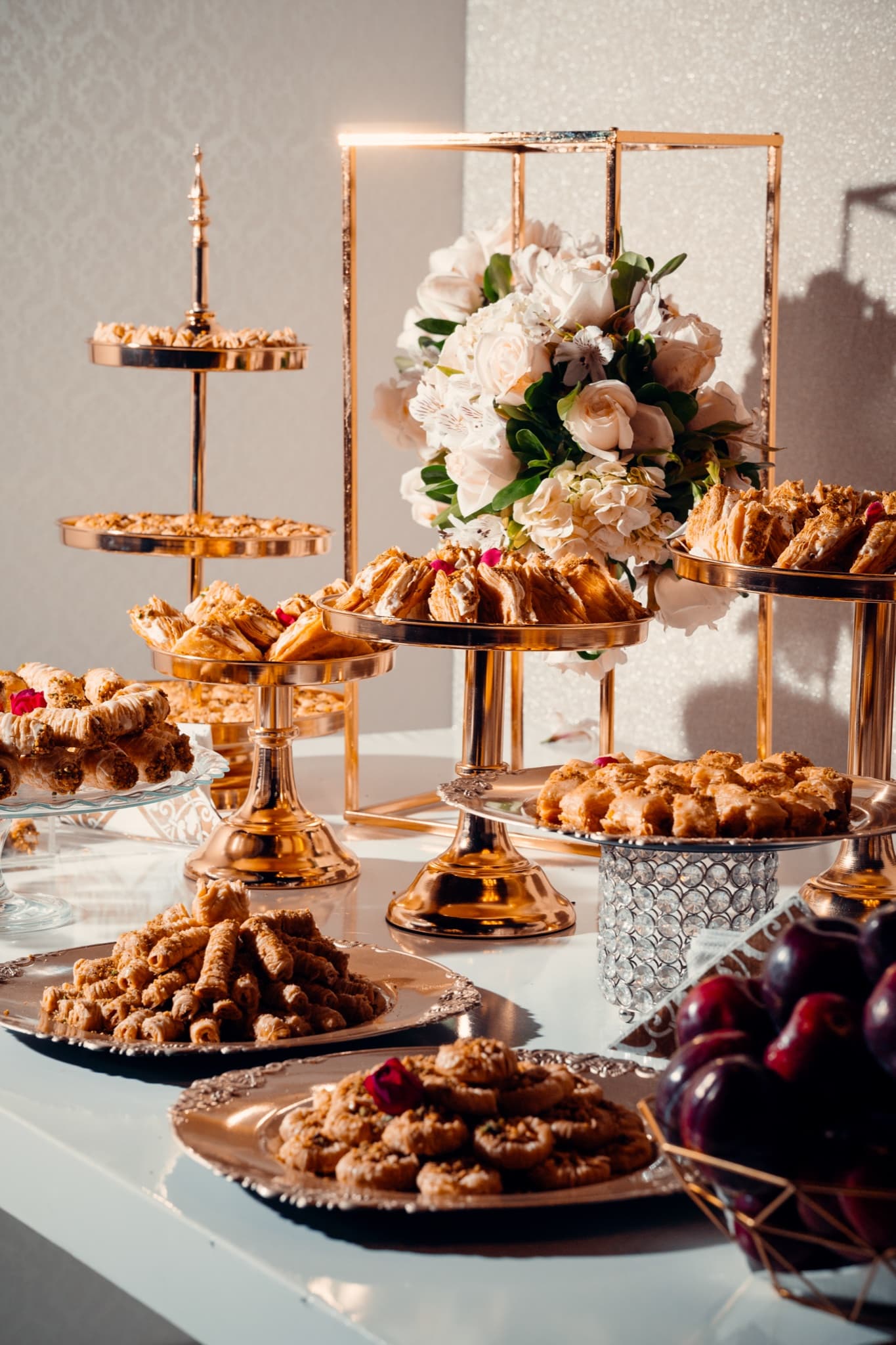 Mesa de dulces y flores iluminada durante una celebración