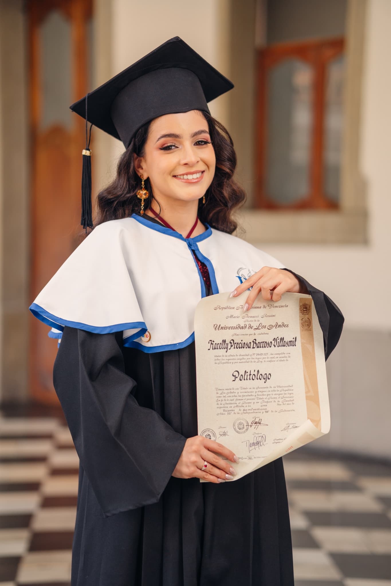 Graduada con toga y birrete mostrando su diploma universitario